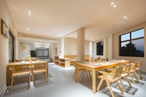 a dining room with wooden tables and chairs at Floral Hotel Jiuhuashan Xiluzhanyi B&B in Chizhou +22 photos