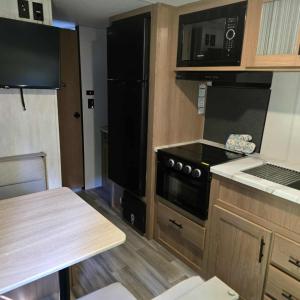 a small kitchen with a stove and a microwave at Monday creek camper in New Straitsville +10 photos