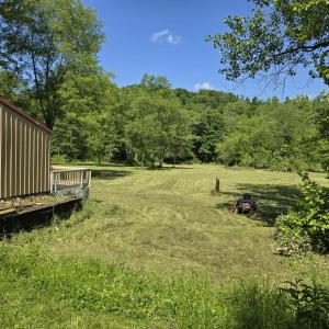 a field with a tractor parked in the grass at Monday creek camper in New Straitsville