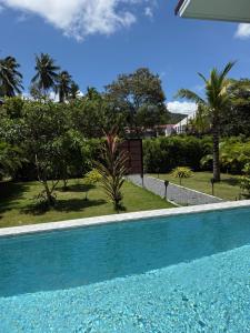 a blue swimming pool in a yard with trees at Private Pool Residences in Ko Phangan