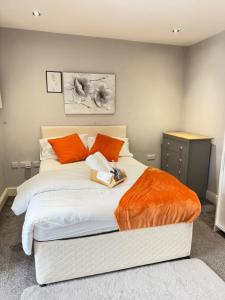 a bedroom with a large bed with orange pillows at Lovely Double Bedroom in Liverpool