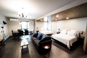 a living room with two beds and a couch at Motel Le Martinet in La Pocatiere