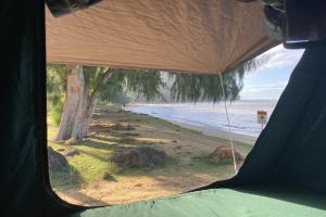 a view of the beach from inside a tent at Drive & Camp Kauai Rooftop Tent Camper Full Camping Kit in Anahola +1 photo