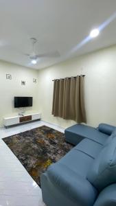 a living room with a blue couch and a rug at ABG JEFF HOMESTAYs in Bukit Payong