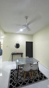 a dining room with a glass table and chairs at ABG JEFF HOMESTAYs in Bukit Payong