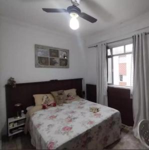 une chambre avec un lit et un ventilateur de plafond dans l'établissement Lindo apto frente mar em região privilegiada de Santos, à Santos