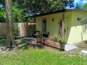 a small yellow house with plants in a yard at Deep Sea Dreams in Pensacola