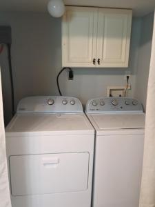 two washing machines in a kitchen with a cabinet at Winter Escape Pet Friendly Cottage with Jacuzzi Tub and Reading Nook in Pensacola +78 photos