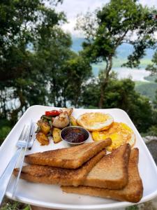 un plato de desayuno con tostadas y huevos en Escape by feel good, en Pokhara