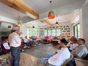 Un hombre hablando con un grupo de personas en una habitación. en Escape by feel good, en Pokhara