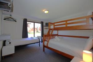 two bunk beds in a room with a window at Alpha Centauri - 8 - 39 Gippsland Street in Jindabyne
