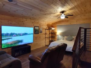 a bedroom with a large screen television in a log cabin at TheGapCabin in Buffalo Gap