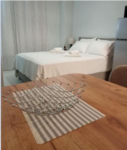 een slaapkamer met een bed en een houten tafel bij Studio 4, Kalamata in Kalamata