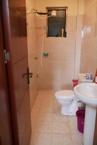 a bathroom with a shower and a toilet and a sink at Maya City View Studios in Nairobi