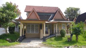 a small yellow house with a porch at Villa Dalia Puncak M4-3 in Cikundul