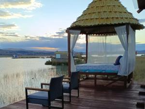 a gazebo with chairs and a bed on a deck at Brisas del Titicaca Perú in Puno