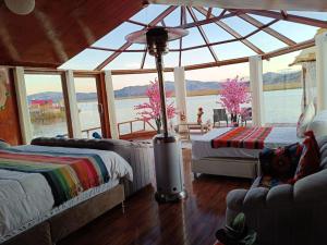 a room with two beds and a large window at Brisas del Titicaca Perú in Puno +12 photos