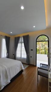 a bedroom with a bed and a large window at Villa Dalia Puncak NA6-06 in Cimacan