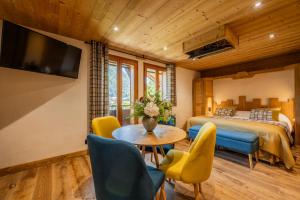 a bedroom with a bed and a table and chairs at Hôtel Le Sporting in Morzine
