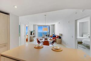 Una cocina y una sala de estar con mesa y sillas. en 2BR Apt with Amazing Ocean View Balcony & Pool, en Beverley Beach