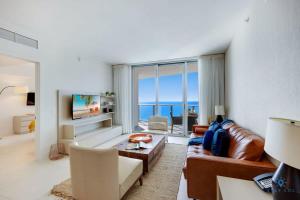 Una sala de estar con un sofá y vista al mar. en 2BR Apt with Amazing Ocean View Balcony & Pool, en Beverley Beach