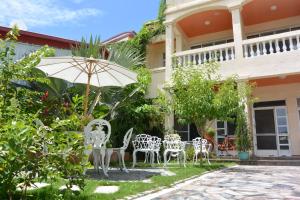 a group of chairs and an umbrella in front of a house at Bellalia 貝拉利亞 花蓮民宿 in Hualien City