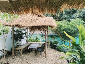 a hut with a table and chairs and a thatch roof at PaiPaiHostel in Pai