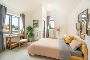 a bedroom with a bed and a desk and window at Homey Villa in Da Lat