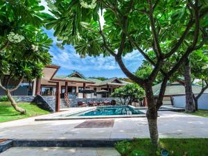 a swimming pool in front of a house at Idyllic Samui Beach Villa Resort in Choeng Mon Beach