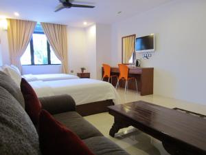 a hotel room with a bed and a couch and a table at AG Hotel Penang in George Town