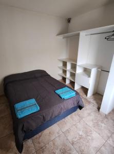 a bedroom with a bed with blue sheets and shelves at Depto Civora 3 in Villa Regina