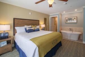 a bedroom with a large bed and a bath tub at RiverWalk Resort at Loon Mountain in Lincoln +30 photos