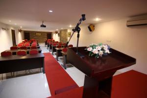 una sala de conferencias con sillas rojas y un podio con micrófono en AG Hotel Penang, en George Town