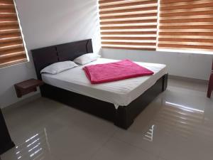Red Chill Resort في فاغامون: غرفة نوم مع سرير مع بطانية حمراء عليه
