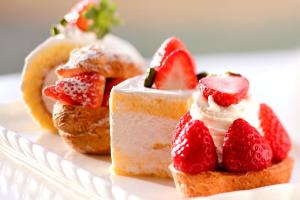 ein Stück Kuchen mit Erdbeeren auf einem Teller in der Unterkunft Wakayama Marina City Hotel in Wakayama