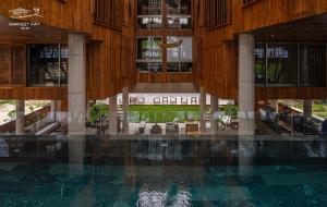 a swimming pool in a building with tables and chairs at Harvest Day Hoi An in Hoi An