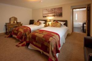 a bedroom with two beds and a bathroom at Borve House Hotel in Borve