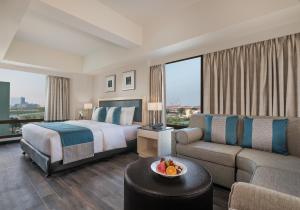 una camera d'albergo con un letto e un divano di Seda Atria a Città di Iloilo