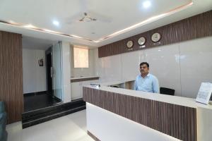 a man standing behind a counter in a room at Hotel Hari Kripa Dham Near Prem Mandir Vrindavan in Vrindāvan