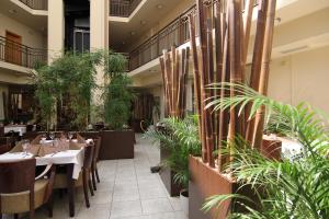 a restaurant with tables and potted plants at Hotel Theresia in Kolín