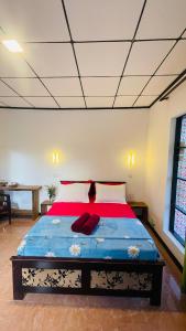 a bedroom with a large bed with red sheets at Ella Compass in Ella +6 photos