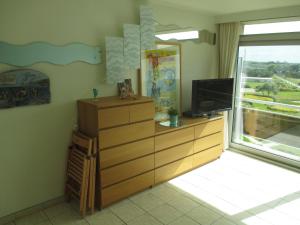 een woonkamer met een tv en een dressoir bij Studio with sea view and panoramic view in Bredene in Bredene