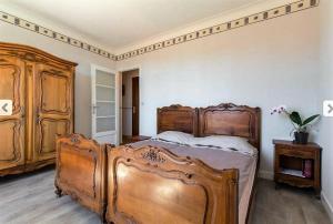 una camera con un grande letto in legno e un comò di Villa Lerina a Cannes