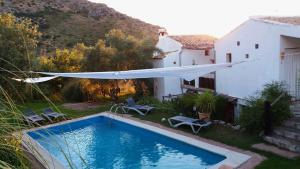 - une piscine dans une cour avec une maison blanche dans l'établissement Posada Niña Margarita, à Priego de Córdoba
