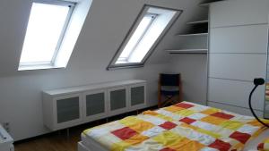 a bedroom with three windows and a bed in it at Country and Town in Unterhaching