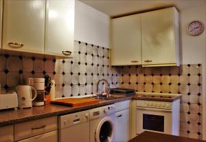 a kitchen with white cabinets and a washing machine at Weststadtblick in Heidelberg