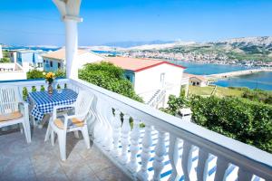 a balcony with a table and chairs and a view of the water at Apartments Toro in Pag