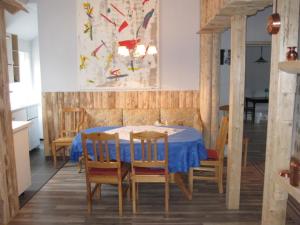 a dining room with a blue table and chairs at Gamla Skolan Bed And Breakfast in Gubbhögen