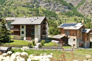 a group of houses with mountains in the background at Pollux Family Apartment in Zermatt