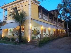 um edifício com uma palmeira em frente em Galeria & Suites Canto do Sol em Barra Grande